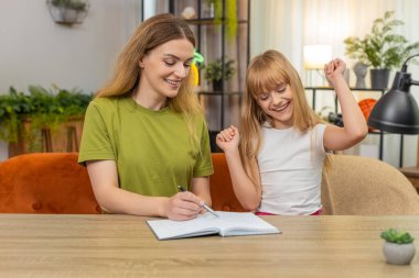 Evdeki anne ve kızı kağıt üzerinde çekiliş şebekesi kuruyorlar. Hızlı kurşunlar not defterinde skor tutuyor. Masa Mark Cross ve Noughts 'daki kadın ve kız..