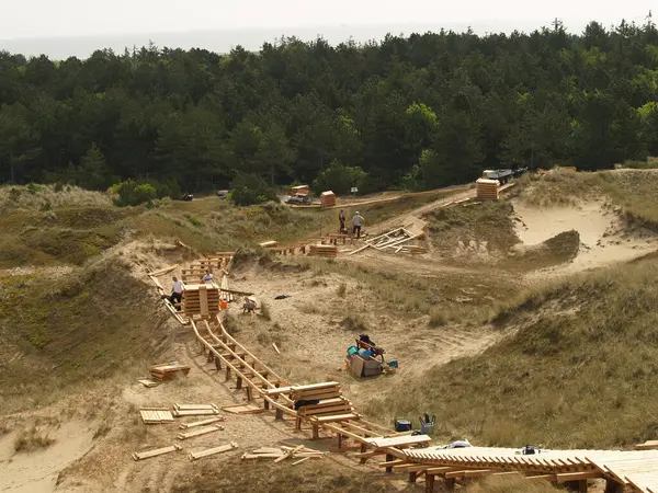 Tahta patikalardan yapılmış kumullar arasında