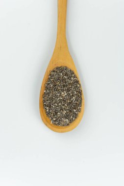 Beyaz arka planda tahta kaşıkta chia tohumları