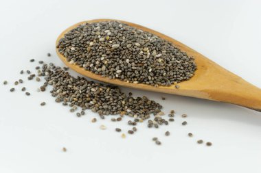Beyaz arka planda tahta kaşıkta chia tohumları