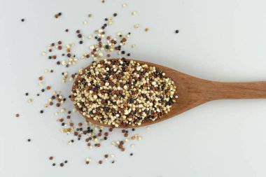 Beyaz arka planda ahşap kaşıkta kinoa tohumu karışımı izole edilmiş üst görünüm