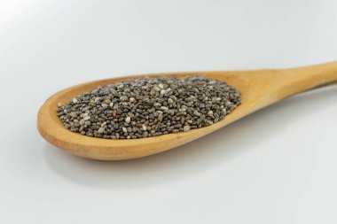Beyaz arka planda izole edilmiş tahta kaşıkta chia tohumları