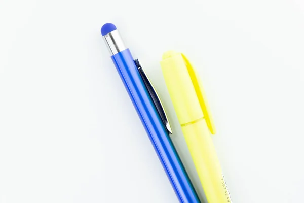 stock image close up of a blue pencil and a yellow highlighter isolated on white background