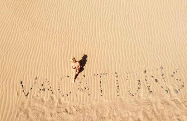 这个词从上方俯瞰沙丘 暑假背景 在沙滩上摆出 Vacations 字样的女人 Vacations Concept — 图库照片