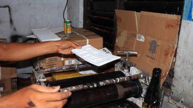 Workers making white license plates for a new type of motor vehicle, Pekalongan, Indonesia, October 17, 2022