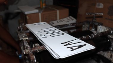 Workers making white license plates for a new type of motor vehicle, Pekalongan, Indonesia, October 17, 2022