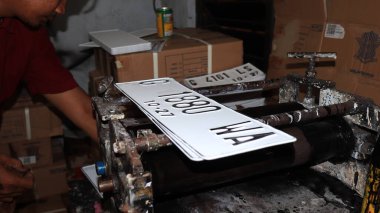 Workers making white license plates for a new type of motor vehicle, Pekalongan, Indonesia, October 17, 2022