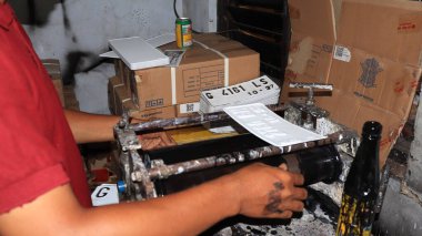 Workers making white license plates for a new type of motor vehicle, Pekalongan, Indonesia, October 17, 2022