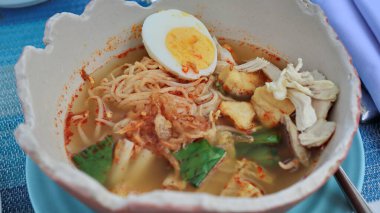Soto Mie, Traditional beef noodle soup with spring roll, cabbage, eggs Noodles with chicken, dumplings and vegetables is Indonesia popular food.