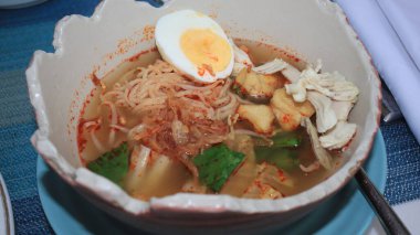 Soto Mie, Traditional beef noodle soup with spring roll, cabbage, eggs Noodles with chicken, dumplings and vegetables is Indonesia popular food.