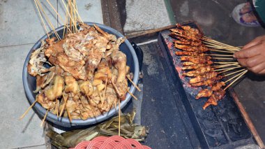 The process of burning satay on the burning coals. satay on fire with smoke and an appetizing look. hands cooking satay on the grill
