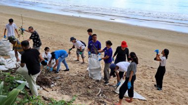 a group of people clean up trash on Jimbaran beach Bali December 9 2022