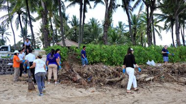 a group of people clean up trash on Jimbaran beach Bali December 9 2022