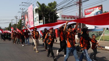 28 Ağustos 2023 'te Pekalongan Endonezya' da düzenlenen Bağımsızlık Günü Karnavalı sırasında Endonezya kırmızı ve beyaz bayrak taşıyan birlikler