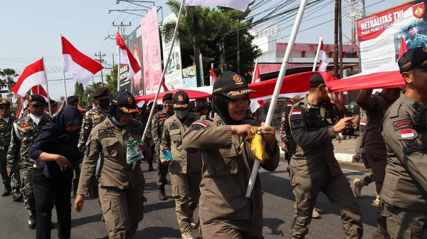2023年8月28日独立日印度尼西亚人民狂欢节期间手持印度尼西亚红白国旗的部队 — 图库照片