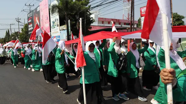 28 Ağustos 2023 'te Pekalongan Endonezya' da düzenlenen Bağımsızlık Günü Karnavalı sırasında Endonezya kırmızı ve beyaz bayrak taşıyan birlikler