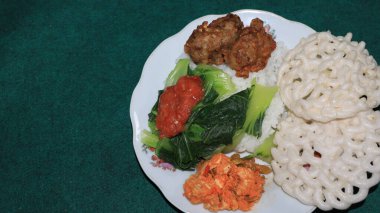 Beyaz pilav, taze hardal yeşillikleri yanında kırmızı biber soslu Tempeh unu, sağlıklı bir yemek menüsü.