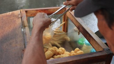 Endonezyalı sokak yemekleri satıcısı Tahu Bulat olarak bilinen yuvarlak tofu satıyor, Endonezya 'da soya peynirinden yapılan popüler aperatif.