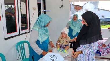 İlkokul öğrencilerine çocuk felci aşısı dağıtılıyor. Daha büyük bir salgını önlüyor. Pekalongan Endonezya 16 Ocak 2024