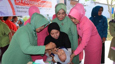 Daha büyük bir salgını önleyen çocuk felci aşısı damlacıklarına verilen ilkokul öğrencileri, Pekalongan Endonezya 16 Ocak 2024