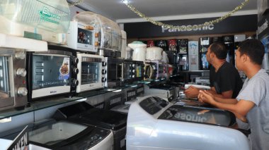 5 Şubat 2024 'te Pekalongan Endonezya' da müşterilere hizmet ederken elektronik mağazası sahibi