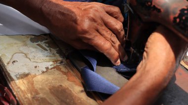 Endonezya 'da sokak terzileri tarafından kullanılan el dikiş makinesinin denge çarkını kapat