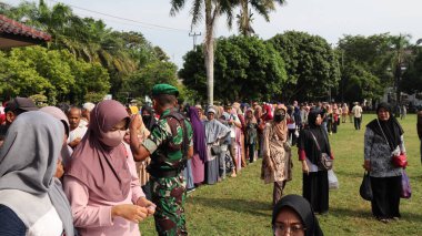 8 Mart 2024 'te hükümet Pekalongan Endonezya' nın ucuz temel ihtiyaçlarını satın almak için kuyrukta bekleyenler