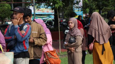 8 Mart 2024 'te hükümet Pekalongan Endonezya' nın ucuz temel ihtiyaçlarını satın almak için kuyrukta bekleyenler