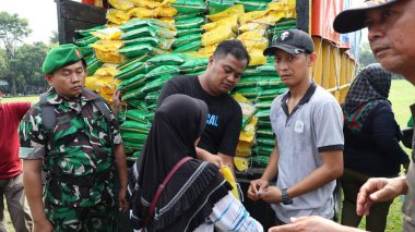8 Mart 2024 'te hükümet Pekalongan Endonezya' nın ucuz temel ihtiyaçlarını satın almak için kuyrukta bekleyenler