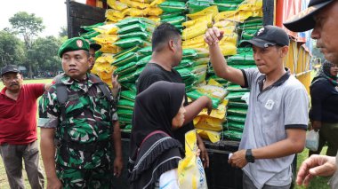 8 Mart 2024 'te hükümet Pekalongan Endonezya' nın ucuz temel ihtiyaçlarını satın almak için kuyrukta bekleyenler