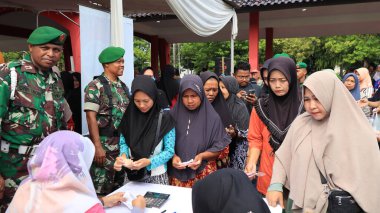 8 Mart 2024 'te hükümet Pekalongan Endonezya' nın ucuz temel ihtiyaçlarını satın almak için kuyrukta bekleyenler