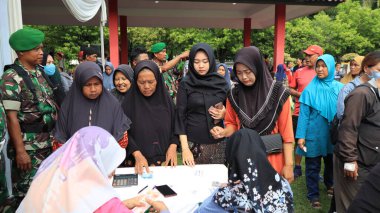 8 Mart 2024 'te hükümet Pekalongan Endonezya' nın ucuz temel ihtiyaçlarını satın almak için kuyrukta bekleyenler