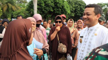8 Mart 2024 'te hükümet Pekalongan Endonezya' nın ucuz temel ihtiyaçlarını satın almak için kuyrukta bekleyenler