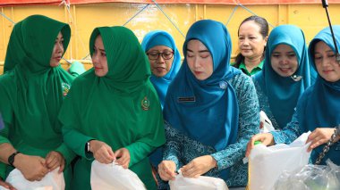 8 Mart 2024 'te hükümet Pekalongan Endonezya' nın ucuz temel ihtiyaçlarını satın almak için kuyrukta bekleyenler