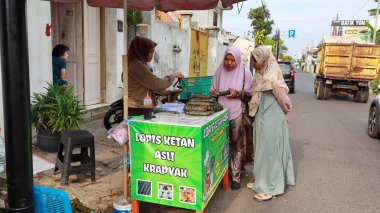 Lopis Lupis 'in tedarikçisi 15 Nisan 2024' te Pekalongan 'da müşterilere servis yaparken yapışkan pirinçten yapılan geleneksel Endonezya tatlı keki.