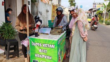 Lopis Lupis 'in tedarikçisi 15 Nisan 2024' te Pekalongan 'da müşterilere servis yaparken yapışkan pirinçten yapılan geleneksel Endonezya tatlı keki.