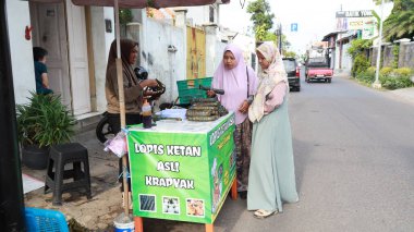 Lopis Lupis 'in tedarikçisi 15 Nisan 2024' te Pekalongan 'da müşterilere servis yaparken yapışkan pirinçten yapılan geleneksel Endonezya tatlı keki.