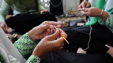 Yün ören bir kadın. Kadın eli, yakın plan. El yapımı. Renkli iplik ve örgü iğneleri.