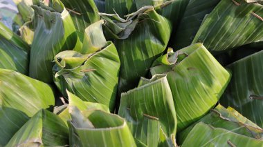 Muz yapraklarına sarılmış geleneksel pirinç, muz yapraklarına sarılmış megono pilavı.