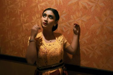 Endonezyalı seksi kadın, güzel yüzlü, Kebaya giymiş ve Batik kameraya bakıyor.