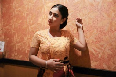 Endonezyalı seksi kadın, güzel yüzlü, Kebaya giymiş ve Batik kameraya bakıyor.