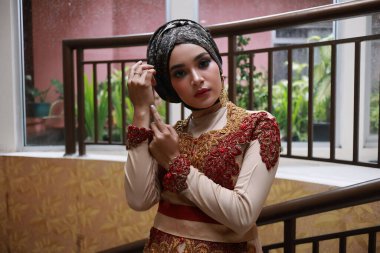 Güzel görünümlü Endonezyalı kadın tesettür takıyor ve Kebaya güzel bir batik kumaşa sarılmış.