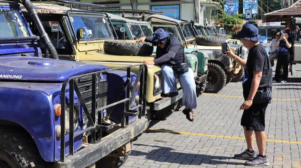 Turistler, Lembang Endonezya, 23 Haziran 2024 tarihli klasik bir arazi aracıyla doğada seyahat ederler.