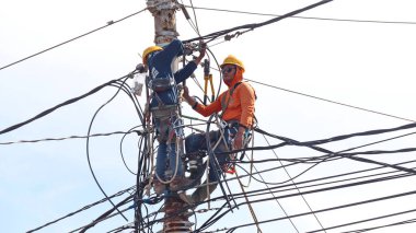 Elektrik teknisyeni, elektrik direği, Pekalongan Endonezya 'da 10 Temmuz 2024' te tırmanış işçiliği yapıyor.