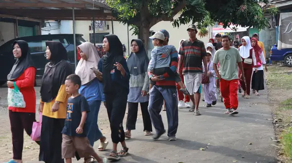 Köylüler, Jalan Sehat ya da sağlıklı yürüyüş etkinliği olan Batang Endonezya 16 Ağustos 2024 sabahına kadar kırsal bir yol boyunca birlikte yürüyorlar.