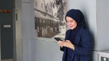 Telefonla çalışan Asyalı Müslüman bir kadın. Tesettürlü, cep telefonu tutan neşeli Asyalı kadın. Reklam kavramı
