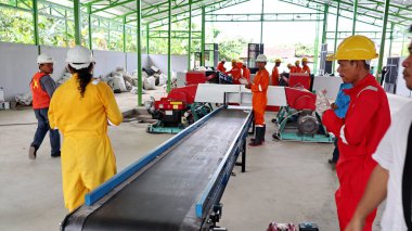 Geri dönüşümlü materyalleri sınıflandırmak için atık işleme fabrikasında çalışırken güvenlik kıyafeti ve kask giyen işçilerin portresi, Pekalongan Endonezya 10 Ocak 2025