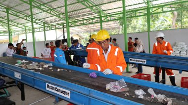 Geri dönüşümlü materyalleri sınıflandırmak için atık işleme fabrikasında çalışırken güvenlik kıyafeti ve kask giyen işçilerin portresi, Pekalongan Endonezya 10 Ocak 2025