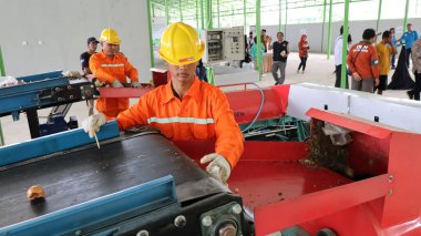 Geri dönüşümlü materyalleri sınıflandırmak için atık işleme fabrikasında çalışırken güvenlik kıyafeti ve kask giyen işçilerin portresi, Pekalongan Endonezya 10 Ocak 2025
