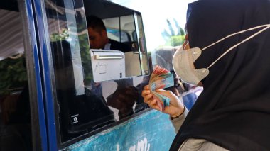İnsanlar Endonezya Bankası tarafından organize edilen mobil nakit kamyonetinde yeni rupiah banknotları değiş tokuş ediyorlar, para değiş tokuşu kuyrukları, Pekalongan Endonezya 11 Mart 2025